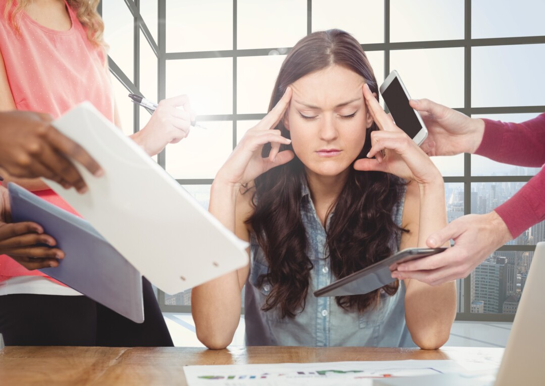 Stressed woman sitting with hands on forehead